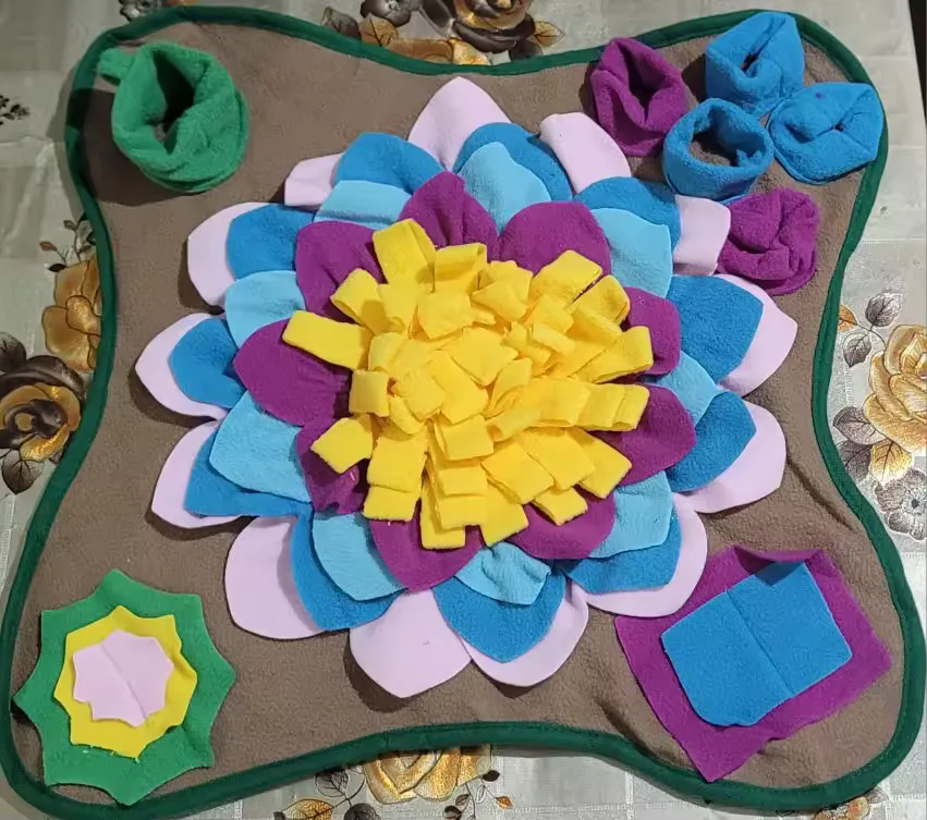 Buyer photo: close-up of the Earth brown snuffle mat, yellow flower core with magenta, pink and blue petals and a green trim