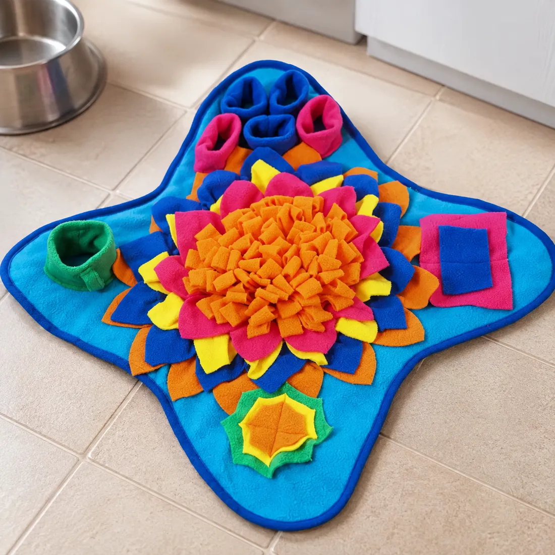 The Ocean snuffle mat on pale kitchen tiles next to a steel dog bowl